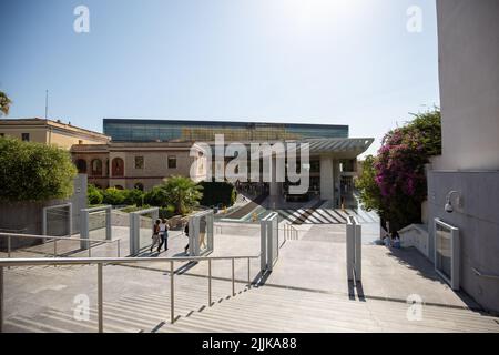 Eine wunderschöne Aufnahme von Menschen, die an einem sonnigen Tag zum Akropolis-Museum auf der Insel Hydra, Griechenland, laufen Stockfoto
