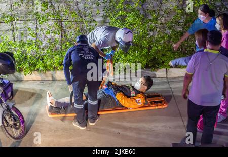 SAMUT PRAKAN, THAILAND, MAI 05 2022, Behandlung eines Motorradkuriers nach einem Unfall Stockfoto