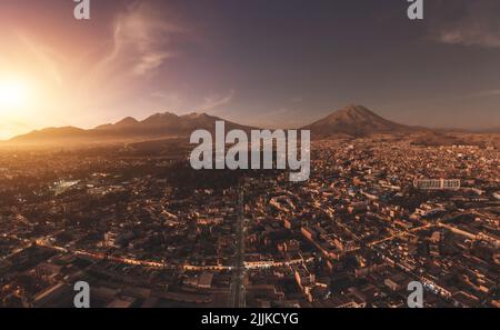 Luftaufnahme eines Sonnenuntergangs in Arequipa Stadt mit Chachani Vulkan als Hintergrund, Peru Stockfoto