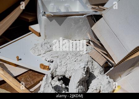 Verschiedene Abfälle in einem Behälter für Abfälle während oder nach einer Renovierung. Es gibt keine Marken oder Personen in der Aufnahme. Stockfoto