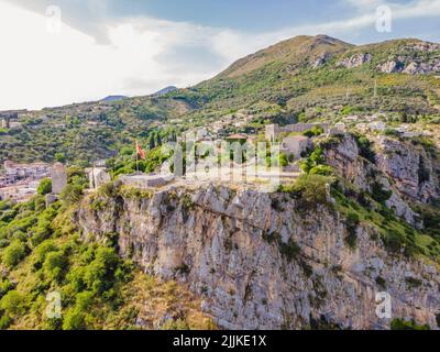 Altstadt. Sonniger Blick auf die Ruinen der Zitadelle in Stari Bar Stadt in der Nähe von Bar Stadt, Montenegro. Drohnenansicht Porträt eines verärgerten Mädchens, das in einem Café sitzt Stockfoto