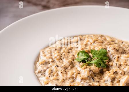 Ein köstliches Pilz-Risotto auf einem Holztisch Stockfoto