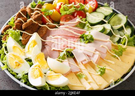 Der klassische Chefsalat ist ein grüner Salat, der mit verschiedenen Aufschnitt-, Käse- und Gemüsesorten serviert wird und in einem hausgemachten Dressing aus der Nähe auf der Plate serviert wird Stockfoto