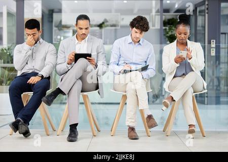 Kreativität fließt in diesem Raum. Eine Gruppe von Menschen warten darauf, für einen Job in einem modernen Büro interviewt zu werden. Stockfoto