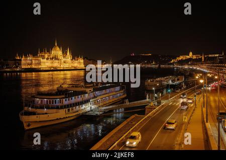 Panoramablick auf das Parlamentsgebäude und die Donau in Budapest, Ungarn. Parlament und Überlegungen . Abendbeleuchtung des Gebäudes. Stockfoto