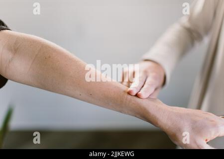 Eine Nahaufnahme von zwei Fingern, die den Puls einer anderen Person überprüfen. Stockfoto