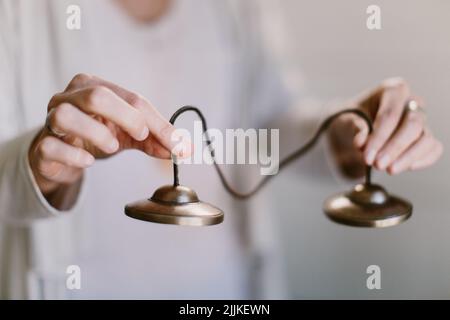 Eine Nahaufnahme der Hände einer Frau mit tibetischen Meditationsglocken. Stockfoto