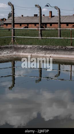 Juni 15 2022: Oswiecim, Polen. Wasserreservoir in der Nähe von Ziegelbaracken im Konzentrationslager Auschwitz-Birkenau Stockfoto