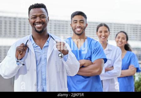 Waren glücklich, wenn Sie glücklich sind. Eine Gruppe von Ärzten, die vor einem Stadthintergrund stehen. Stockfoto