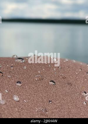 Eine Nahaufnahme von Wassertröpfchen auf der Stoffoberfläche der Straße unter Sonnenlicht Stockfoto