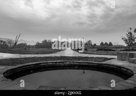 Eine Graustufe des Parks mit Bäumen und Hügeln im Hintergrund Stockfoto