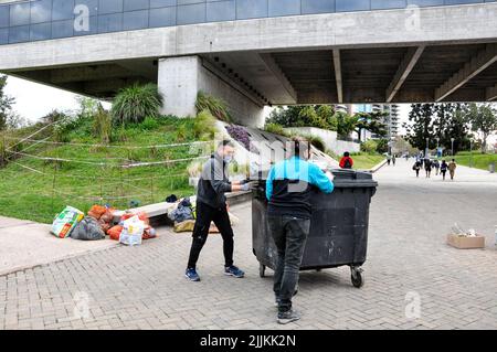 Die Männer, die Abfallcontainer in einem Park tragen Stockfoto