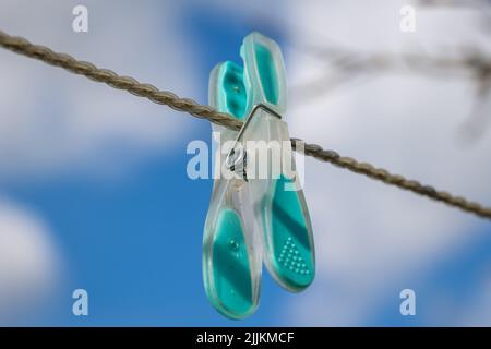 Nahaufnahme eines einzelnen Kleiderstegs an einem Plastikseil Stockfoto