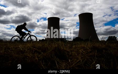 27. Juli 2022, Niedersachsen, Emmerthal: Radler fahren auf dem Weser-Radweg vorbei am stillgelegten Kernkraftwerk Grohnde. Der Verein TÜV glaubt, dass es möglich ist, dass die drei Atomkraftwerke, die Ende letzten Jahres stillgelegt wurden, schnell wieder in Betrieb genommen werden. Nach 36 Jahren wurde das Kernkraftwerk im Weserbergland bei Hamelin am 31. Dezember 2021 vom Netz genommen. Das niedersächsische Umweltministerium geht derweil davon aus, dass die Genehmigung für den Rückbau des Kernkraftwerks Grohnde bis Ende 2022 erteilt wird. Foto: Julian St Stockfoto