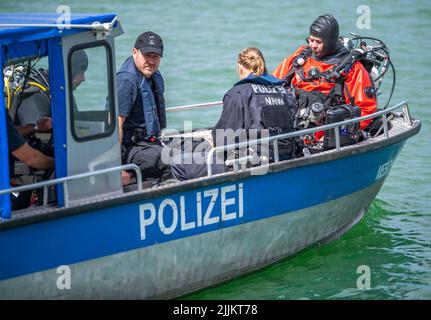 Porta Westfalica, Deutschland. 27.. Juli 2022. Ein Polizeiboot mit Tauchern der Bochumer Taucheinheit fährt auf einem Schotterteich, wo zwei Personen am Sonntag (24.07.2022) aus unerklärlichen Gründen beim Schwimmen nicht an die Oberfläche konnten. Nach Angaben eines Feuerwehrsprechers sind einige Teile des Sees etwa 30 Meter tief. Experten der Polizei wollen nun mit einer Unterwassersonde nach den beiden Menschen suchen. Quelle: Lino Mirgeler/dpa/Alamy Live News Stockfoto