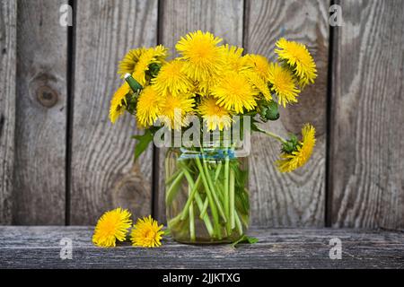 Bouquet von Delaionblüten, gelbe Wildblumen auf altem Holztisch. Stillleben mit wilden Blumen Stockfoto