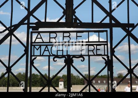 Nazi-Slogan "Arbeit macht frei" am Tor des Jourhausgebäudes, durch das die Gefangenen in das ehemalige Konzentrationslager Dachau, das jetzt KZ-Gedenkstätte Dachau in Dachau bei München in Bayern, Deutschland, eingeliefert wurden. Das ursprüngliche Tor ist jetzt im Museum ausgestellt. Stockfoto