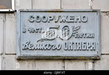 Die Botschaft auf der Steinmauer nach der russischen Sprache: Sie wurde zu Ehren des fünfzigsten Jahrestages des Großen Oktober in Kiew, Ukraine, errichtet. Stockfoto
