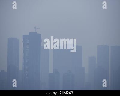 Eine Luftaufnahme einer Stadt mit Hochhäusern, die an einem bewölkten Tag mit Nebel bedeckt sind Stockfoto