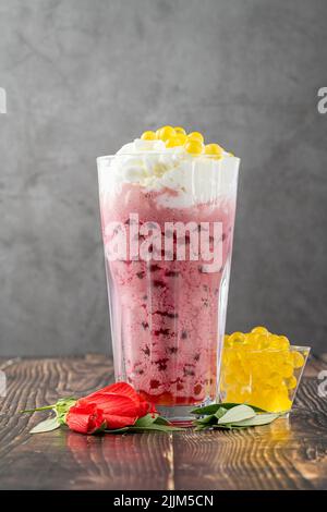 Erdbeer-, Zitronen- und Bubble-Tee-Milchshake oder Smoothie auf einem Holztisch Stockfoto