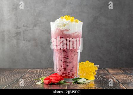 Erdbeer-, Zitronen- und Bubble-Tee-Milchshake oder Smoothie auf einem Holztisch Stockfoto