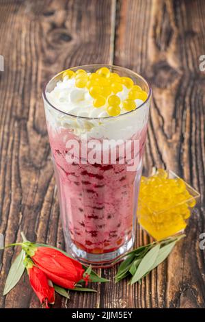 Erdbeer-, Zitronen- und Bubble-Tee-Milchshake oder Smoothie auf einem Holztisch Stockfoto