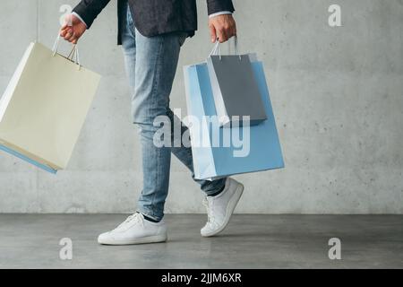 Einkaufstherapie Männer Casual Walking Holding Taschen Stockfoto