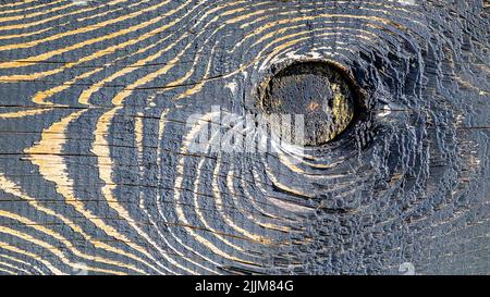 Holzhintergrund. Verbranntes Holz. Schwarze und goldene Farben Stockfoto