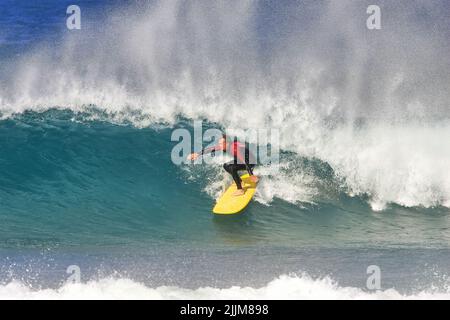 Ein Longboard-Surfer auf einer Welle am Fistral Beach Newquay, Großbritannien Stockfoto