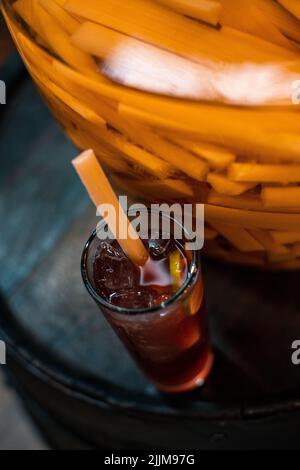 Eine vertikale Aufnahme eines orangefarbenen Cocktails mit einem Strohhalm in einem hohen Winkel Stockfoto