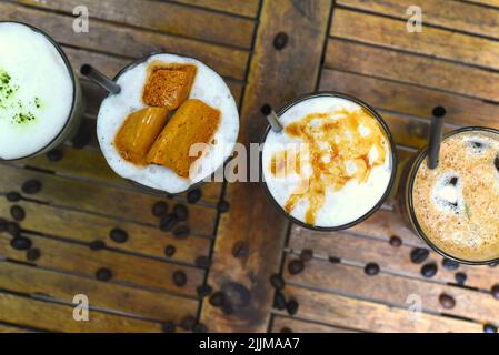 Kaffeegetränke mit Kaffeebohnen auf Holztisch Stockfoto