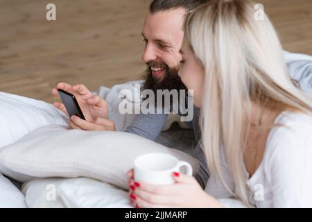 Morgen Paar wecken Mann Frau Tasse Smartphone Stockfoto