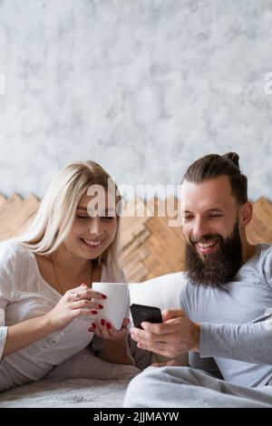 Junges Paar Jubiläumsplanung Check Smartphone Stockfoto