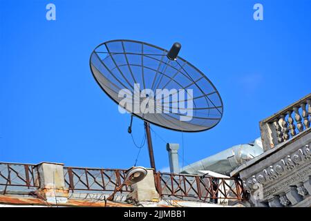Satellitenantenne mit Konvertern auf dem Dach des Gebäudes, moderne Telekommunikationsvielfalt Stockfoto