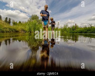 Chorleywood, Großbritannien. 27. Juli 2022. UK Weather – Menschen paddeln im River Chess in Chorleywood, Hertfordshire, einem Kreidestrom mit besonderer Bedeutung für die Tierwelt und die natürliche Umwelt. Die National Dürre Group hat die Menschen im ganzen Land dazu aufgefordert, Wasser während der aktuellen Zeit lang andauernder Trockenheit sinnvoll zu nutzen, um die Wasserversorgung und die Umwelt zu schützen, da das Met Office mehrere weitere trockene Wochen vor sich prognostiziert, insbesondere im Süden und Osten des Landes. Rohrleitungsverbote und Dürrebefehle stehen noch aus. Kredit: Stephen Chung / Alamy Live Nachrichten Stockfoto