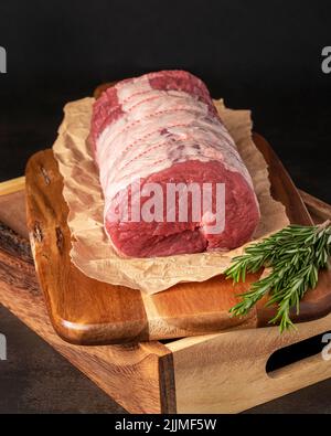 Food Fotografie von Rindfleisch, rohem Steak, Metzger, Filet, Fleisch, Holzbrett, Kräuter Stockfoto