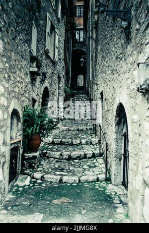 Eine vertikale Graustufenaufnahme einer Steinallee in Dorf, Frankreich Stockfoto