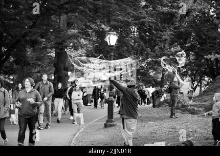 Eine Graustufenaufnahme des Mannes, der im Central Park, New York City, große Blasen machte. Stockfoto