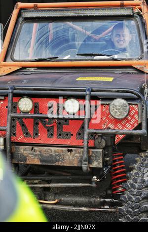 Eine vertikale Aufnahme eines stark modifizierten Lada Niva für die Hardcore-Rallye mit einem lächelnden Fahrer in Novi Pazar, Serbien Stockfoto