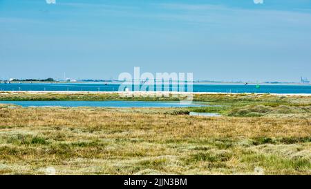 Blick über die Mündung des Swales in Richtung Isle of Sheppey und der KingsFerry-Brücke in Kent, England Stockfoto