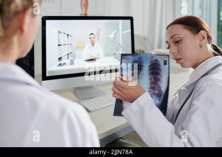 Ärzteteam diskutiert dunklen Sport auf Lunge Röntgenaufnahme des Patienten Stockfoto
