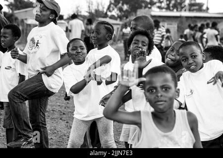 Ein Graustufenporträt afrikanischer Kinder, die auf dem Schulhof in Johannesburg, Südafrika, posieren Stockfoto