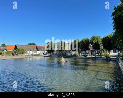 Entenhaus im Dorfteich, umgeben von traditionellen Fachwerkhäusern, Nordby, Samsoe, Jütland, Dänemark Stockfoto