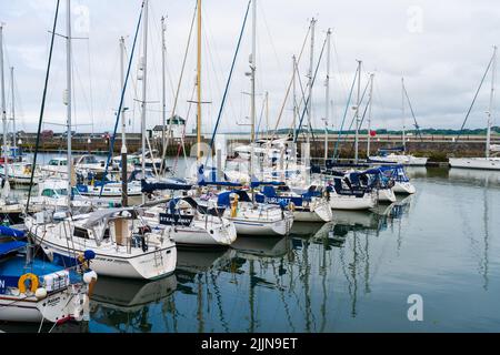 CAERNARFON, WALES - 08. JULI 2022: Boote und Yachten vertäuten im Victoria Dock in Caernarfon, einer königlichen Stadt, Gemeinde und Hafen in Gwynedd, Wales Stockfoto