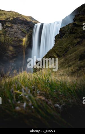 Eine vertikale Aufnahme des Skogafoss Wasserfalls in Island mit langer Belichtung Stockfoto