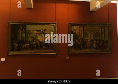 Ein paar Gemälde hängen an der roten Wand des Louvre, Paris, Frankreich Stockfoto