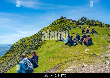 SNOWDON, WALES - 09. JULI 2022: Wanderer auf dem Gipfel des Mount Snowdon, dem höchsten Berg in Wales Stockfoto