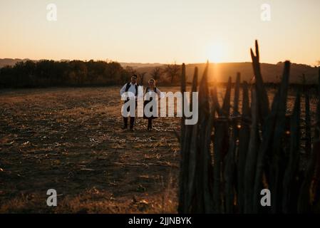 Ein junges Paar in serbischer Tracht bei Sonnenuntergang Stockfoto