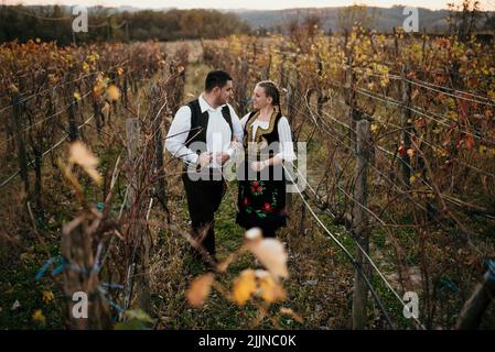 Ein junges Paar in serbischer Tracht bei Sonnenuntergang Stockfoto