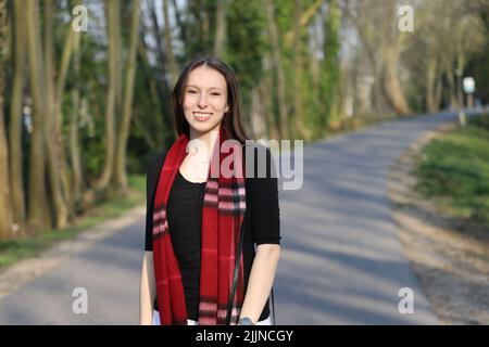 Nahaufnahme einer kaukasischen Frau, die im Park spazieren geht Stockfoto